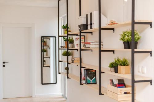 een kamer met planken met planten en een spiegel bij Apartments Šime in Bibinje