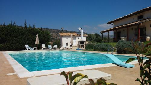 a swimming pool in front of a house at Behara in Marina di Ragusa