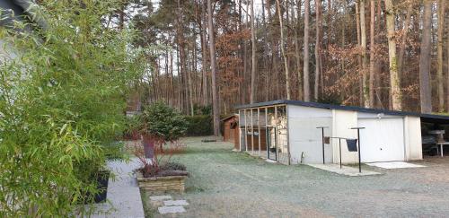 a white shed in the middle of a forest at Etape forêt Fontainebleau climb & randonnées in Arbonne-la-Foret