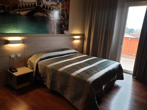 a bedroom with a bed and a large window at Hotel Altieri in Favaro Veneto