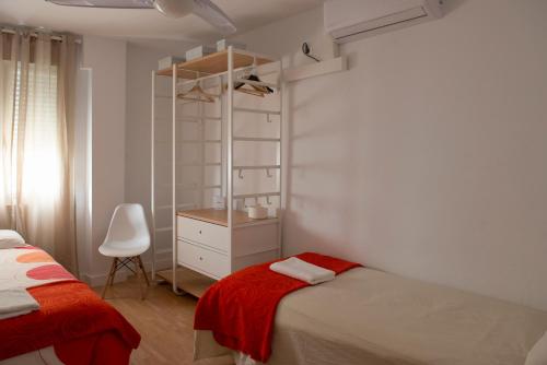 a bedroom with a bed and a dresser and a chair at Casita Coqueta Free Parking in Cádiz