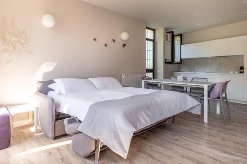 a bedroom with a large bed and a table at CHARMING MOMENT di Villa Porta - Residenza Ortensia in Luino