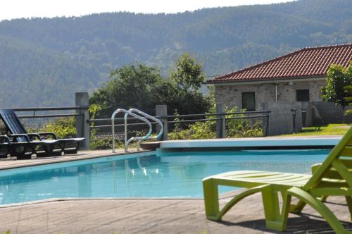 a swimming pool with a slide in a resort at Casa dos Avós by Eira dos Canastros in Espindelo