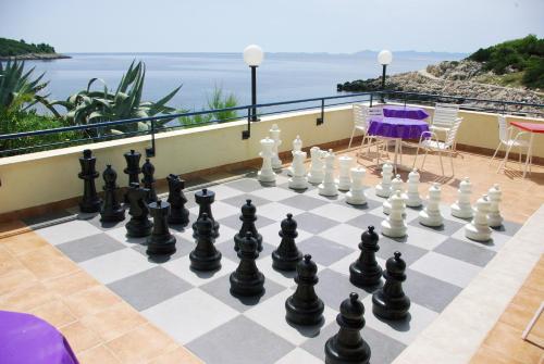 a chess board on a balcony with a view of the ocean at Hotel Priscapac Resort & Apartments in Prizba