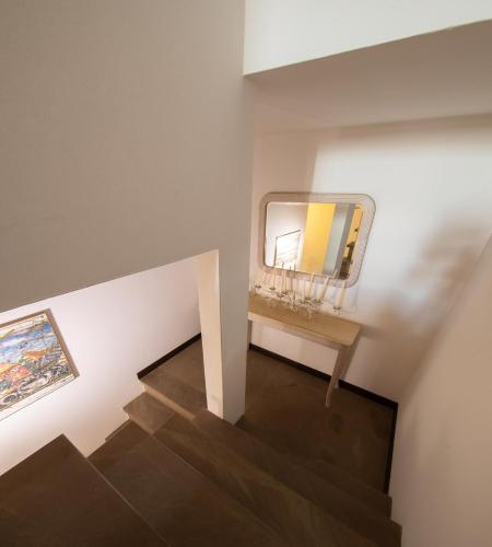 a stairway with a mirror on a white wall at B&B L'Orologio in Signa