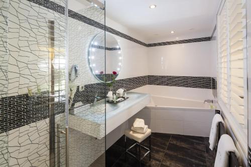 a bathroom with a tub and a sink at Auberge de Cassagne & Spa in Le Pontet