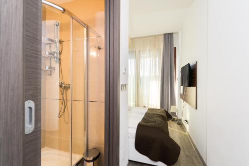 a bathroom with a shower and a bed in a room at Silver Mountain Apartment 26 in Poiana Brasov