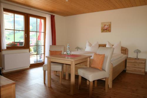 een slaapkamer met een bed en een tafel en stoelen bij Gästehaus Sonnhalde in Wieden