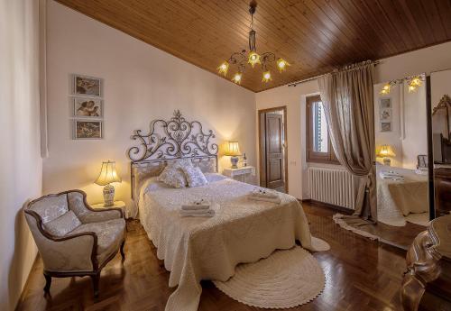 een slaapkamer met een groot bed en een stoel bij B&B L'Orologio in Signa