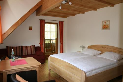 a bedroom with a bed and a chair and a table at Gästehaus Sonnhalde in Wieden