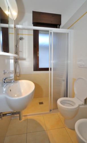 a bathroom with a toilet and a sink at Condominio Pleione in Bibione