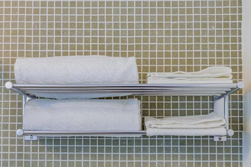 a group of towels on a shelf in a bathroom at Le Maestranze Deluxe Rooms in Sciacca