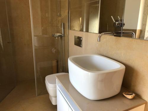 a white bathroom with a sink and a toilet at Azenha do Tio Luís in Caminha