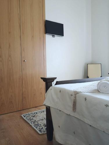 a bedroom with a bed next to a wooden door at Quinta Ribeiro Tanquinhos in Tancos