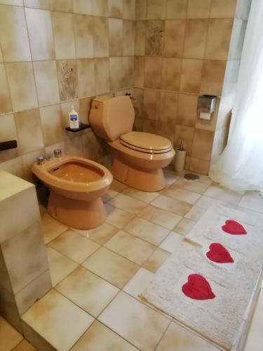 a bathroom with a toilet and a sink and red hearts on the floor at Casa Cenzina in Cosenza