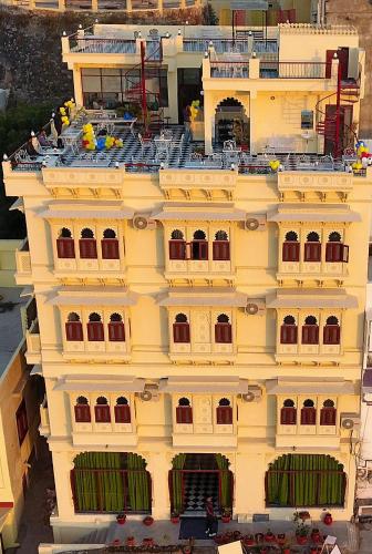 a large yellow building with balconies on it at Hotel Mewari Villa PURE VEG in Udaipur