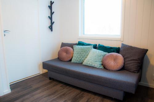 a couch with pillows on it in a room at Nordic Lapland Frevisören in Båtskärsnäs
