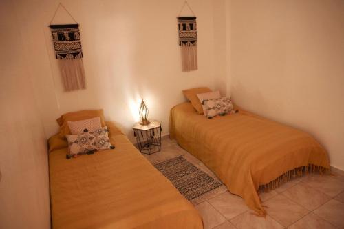 een kamer met twee bedden en een lamp erin bij Dar Océana in Tamraght Ou Fella