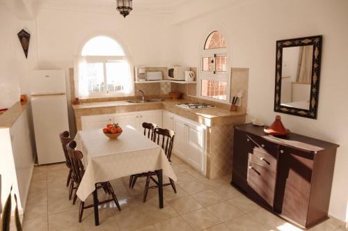 a kitchen with a table and a dining room at Dar Océana in Tamraght Oufella