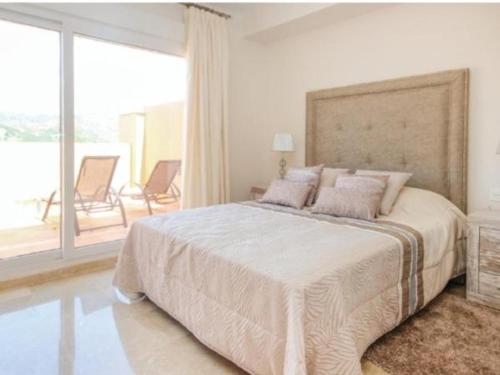 1 dormitorio blanco con 1 cama grande y balcón en Cabopino, en Marbella