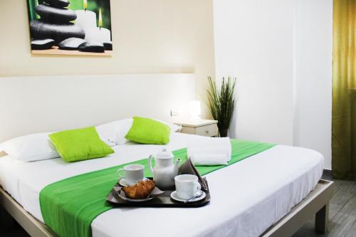 Una cama blanca con una bandeja de comida. en Hotel Cesirja, en Casavatore