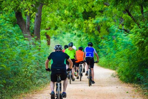 a group of people riding bikes down a dirt road at Sigiri Mango Garden Eco Resort in Sigiriya