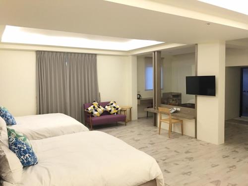 a hotel room with two beds and a flat screen tv at Pisces Garden B&B in Checheng