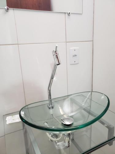 ein Glastisch mit einem Wasserhahn an der Wand in der Unterkunft Executive Plaza Hotel in Núcleo Bandeirante