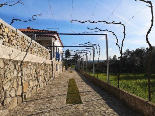 a stone wall next to a road with a fence at Quinta Ribeiro Tanquinhos in Tancos