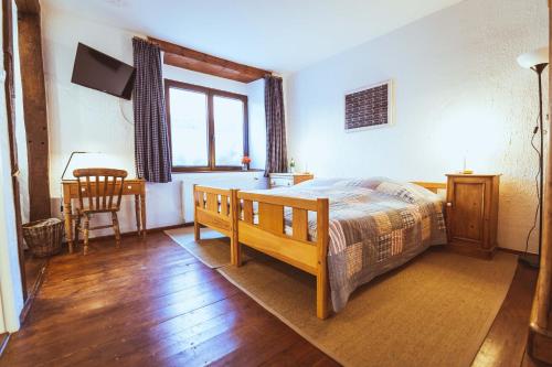 a bedroom with a bed and a table and a desk at Gästehaus Kersting in Meerbusch