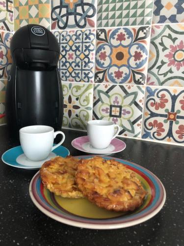 a table with a plate of food and two cups at Central Tavira apartment, Casa Oliverio in Tavira