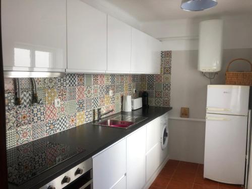 a kitchen with white cabinets and a white refrigerator at Central Tavira apartment, Casa Oliverio in Tavira