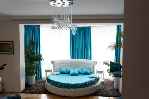 a living room with a bed in front of a window at Garni Hotel Lotos in Niš