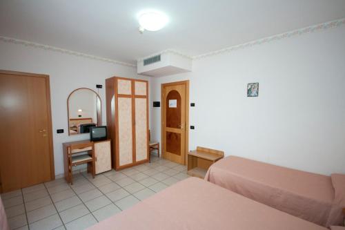 a bedroom with a bed and a vanity and a mirror at Albergo San Michele in San Giovanni Rotondo