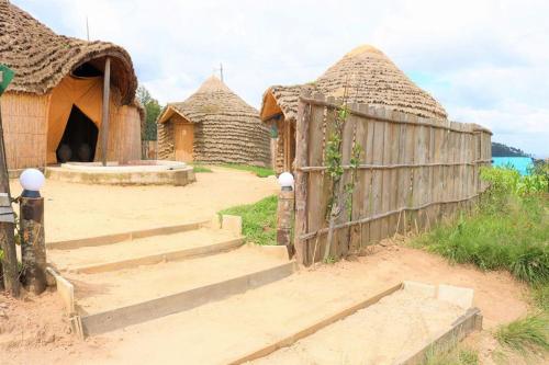 a group of huts with stairs and a fence at Kitabi EcoCenter in Gabegi