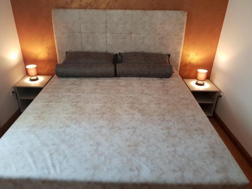 a large bed in a room with two night stands at Apartman KEJ free parking in Kraljevo