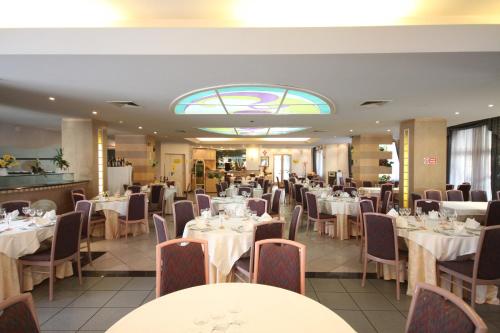 a dining room with white tables and chairs at Albergo San Michele in San Giovanni Rotondo
