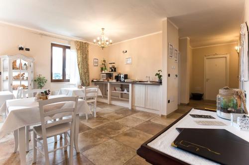 a kitchen and dining room with white tables and chairs at Villa Malvasio Pool and Jacuzzi Room Sassari in Sassari