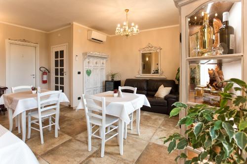 een woonkamer met 2 tafels en een bank bij Villa Malvasio Retreat & Spa in Sassari