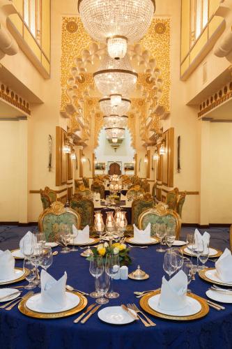 a dining room with a table with plates and glasses at Taj Fateh Prakash Palace Udaipur in Udaipur