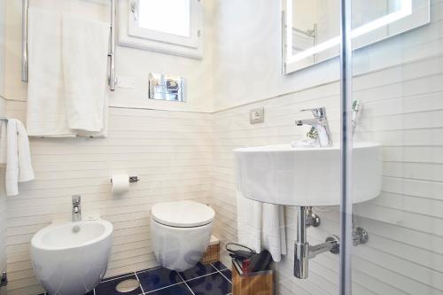a white bathroom with a sink and a toilet at Palazzo Gentilcore in Castellabate