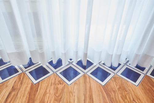 a room with white curtains and a wooden floor at Palazzo Gentilcore in Castellabate