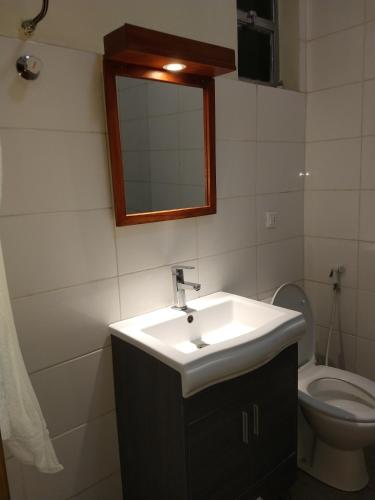 a bathroom with a sink and a toilet and a mirror at Mekelle Hotel in Mekʼelē