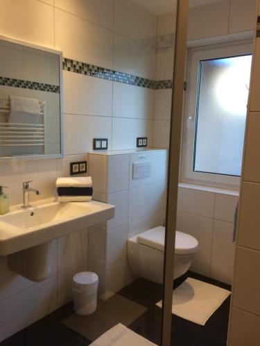 a bathroom with a toilet and a sink and a mirror at Ferienwohnung Lortz in Cuxhaven