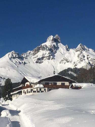 a snow covered mountain with a building in the foreground at Haus Bergfried in Filzmoos