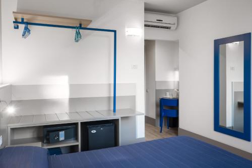 a bedroom with a blue bed and a mirror at Hotel Martini in Verona