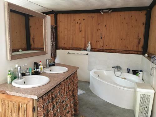 La salle de bains est pourvue de 2 lavabos et d'une baignoire. dans l'établissement Toad Tree Cabins, à Sodwana Bay