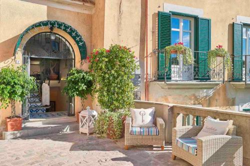 a patio with wicker chairs and plants on a building at Palazzo Gentilcore in Castellabate