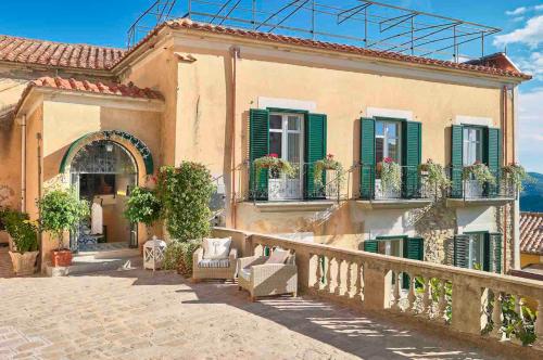 a house with green shutters and a balcony at Palazzo Gentilcore in Castellabate