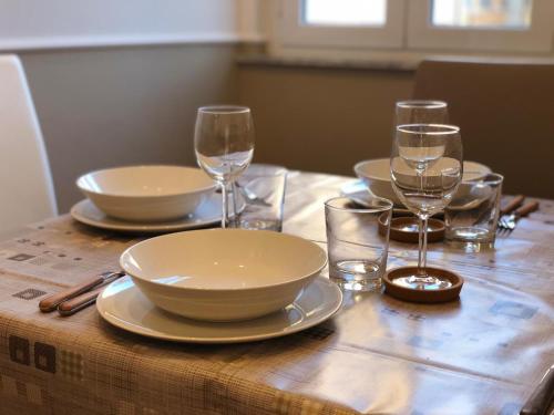 a table with plates and wine glasses on it at Pantheon Luxury Suite in Rome